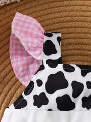 Baby one-piece with cow print, pink gingham ruffle sleeves, and white trim.