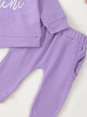Toddler purple waffle knit top and pants set with ruffled trim detail.
