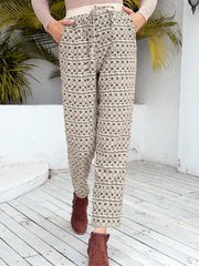 Geometric print drawstring trousers in khaki with cropped, cuffed legs and a relaxed fit.