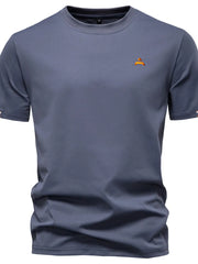 Dusty blue crewneck t-shirt with embroidered orange crest detail on chest