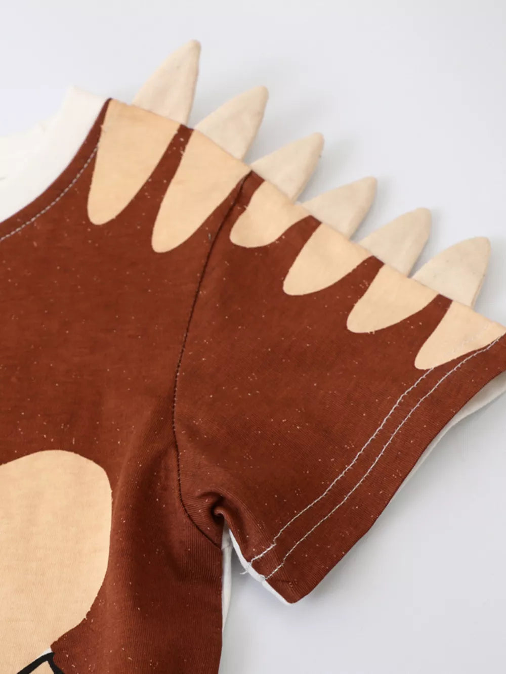 Toddler brown cotton tee with dinosaur spikes on the collar and shoulder detail.