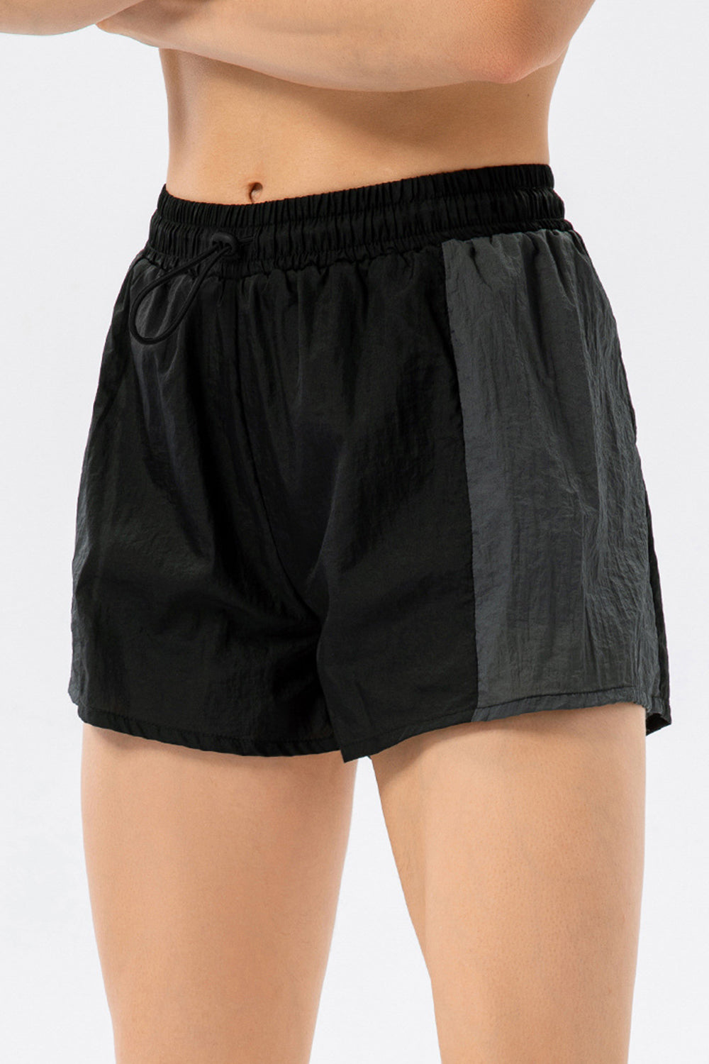 Black and dark grey colorblock performance running shorts with drawstring waist.