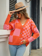 Checkerboard block knit cardigan in orange and pink with V-neck and button front.