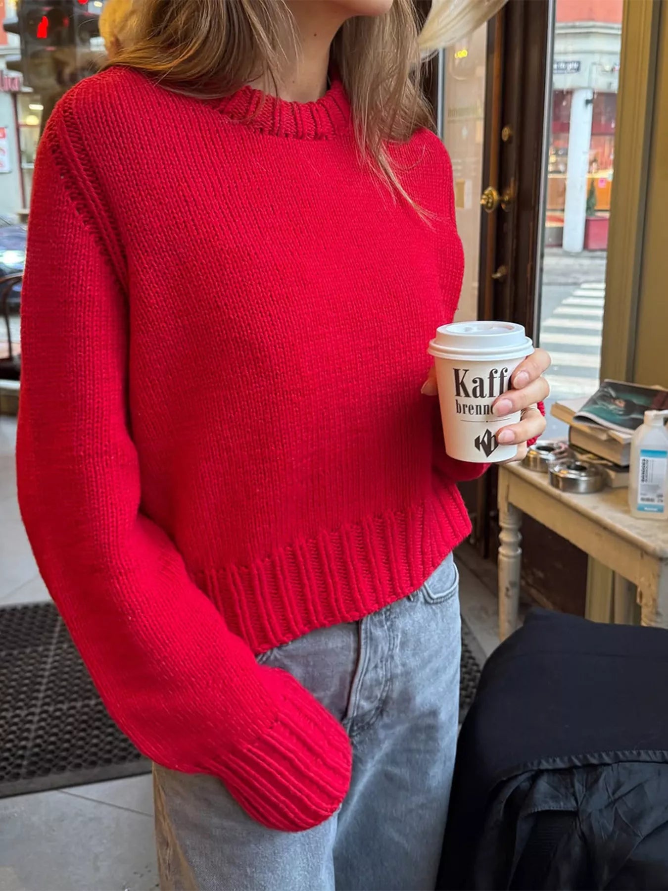 Red ribbed round-neck knit sweater with textured neckline and cuffs.