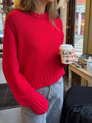 Red ribbed round-neck knit sweater with textured neckline and cuffs.