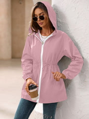 Dusty pink hooded jacket with cinched waistline and white zipper detail.