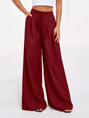 Burgundy high-waisted pleated wide-leg pants with pockets and drawstring waist