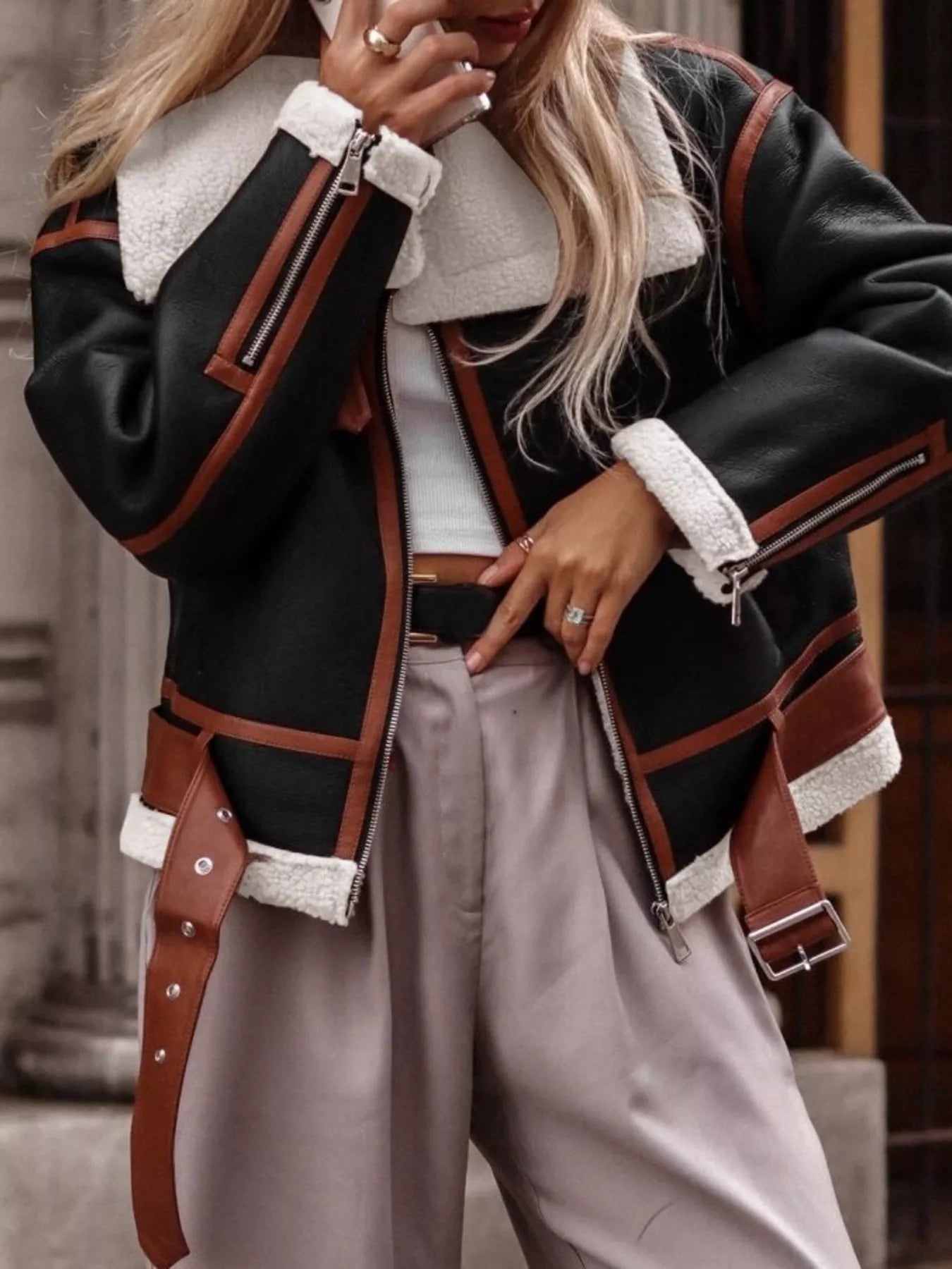 Black shearling lined zip up jacket with brown trim and white sherpa collar and cuffs.