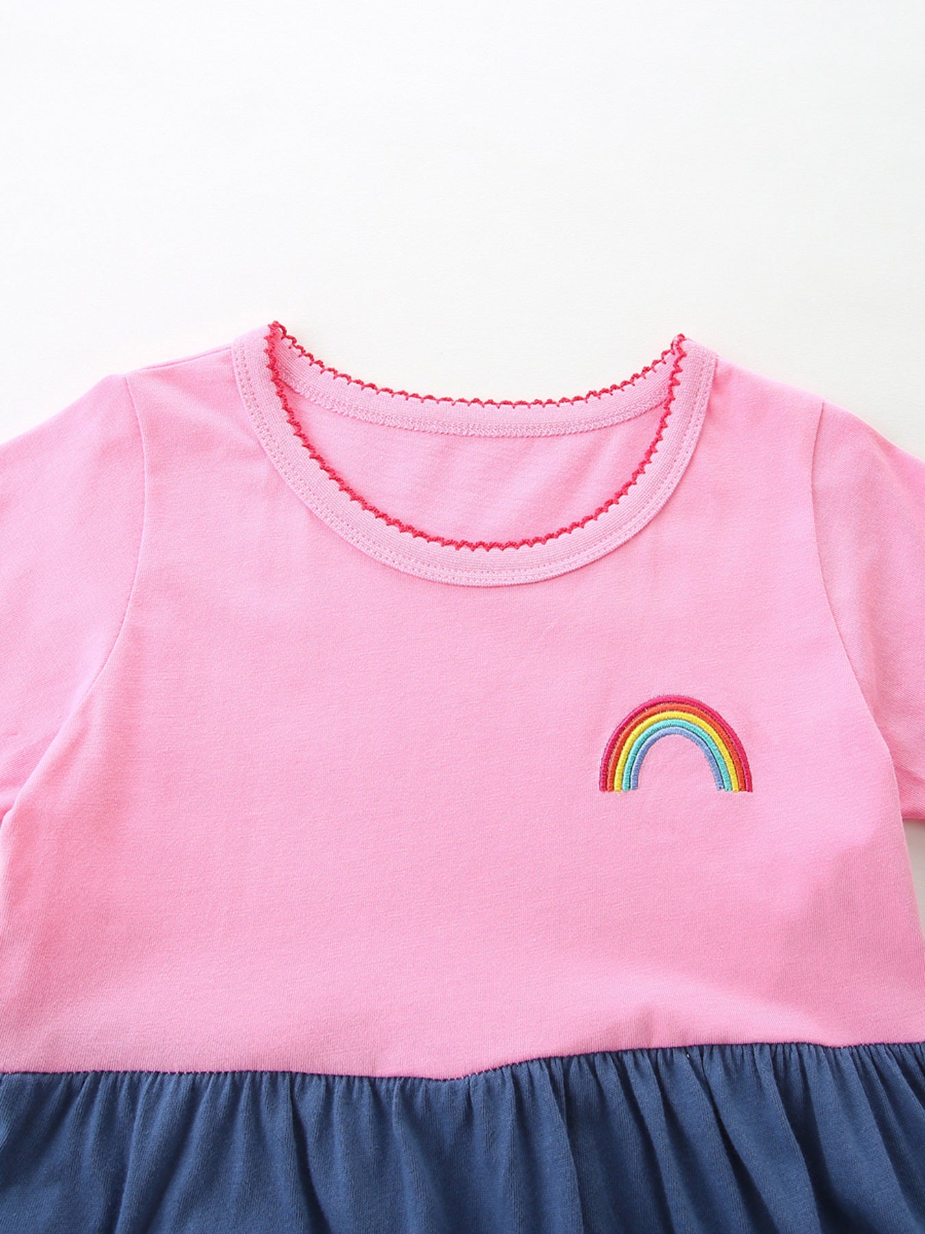 Pink toddler dress with rainbow embroidery and ruffled hem