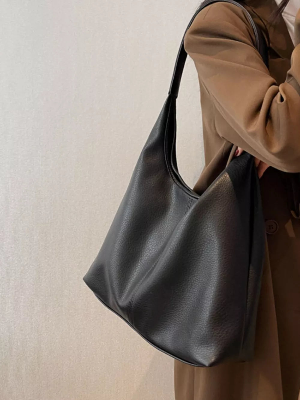 Black pebbled leather hobo shoulder bag with a single strap.