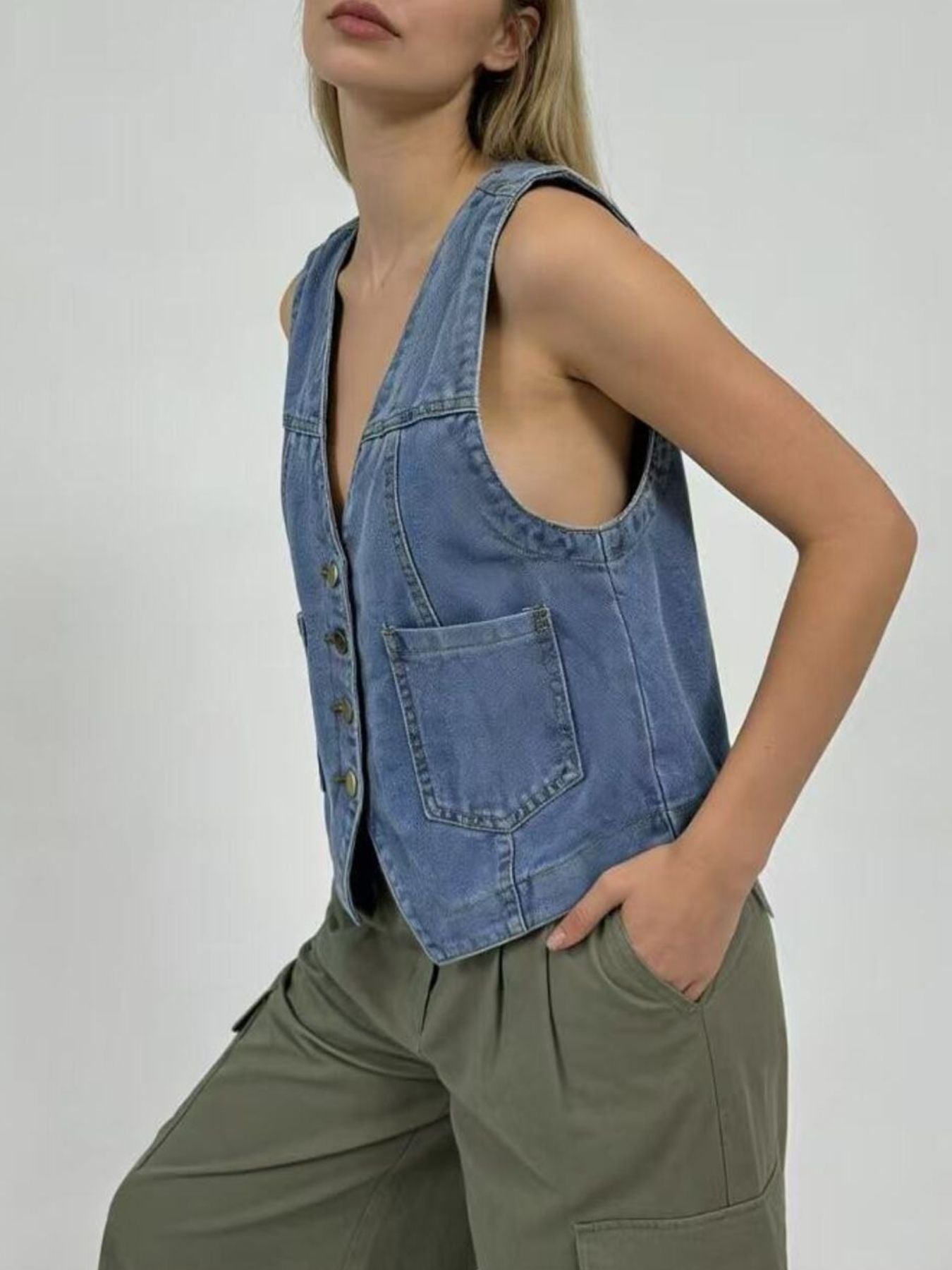 Light blue denim button-down vest with brass buttons and a chest pocket.