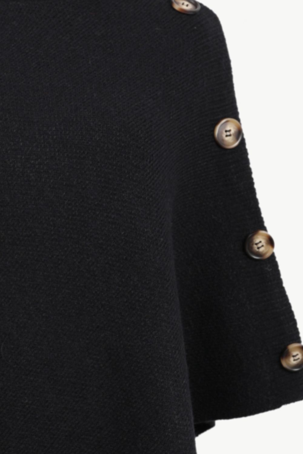 Black acrylic knit poncho with button detail on the side.