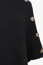 Black acrylic knit poncho with button detail on the side.