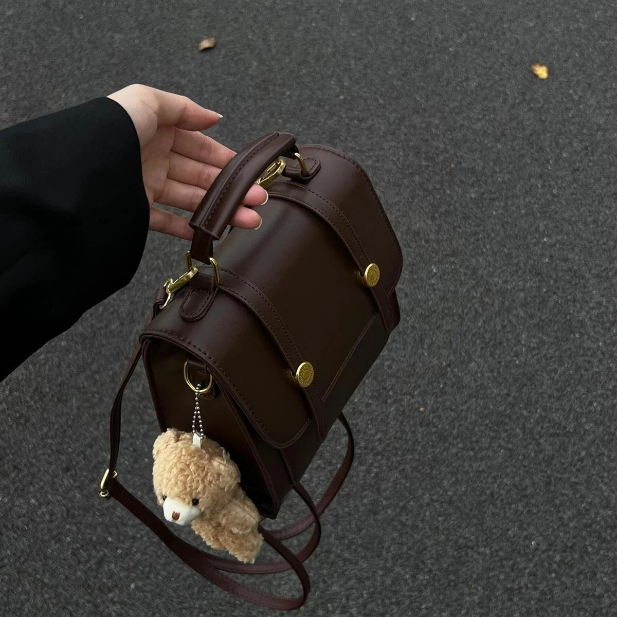 Mini brown pu leather backpack with decorative straps and teddy bear charm.