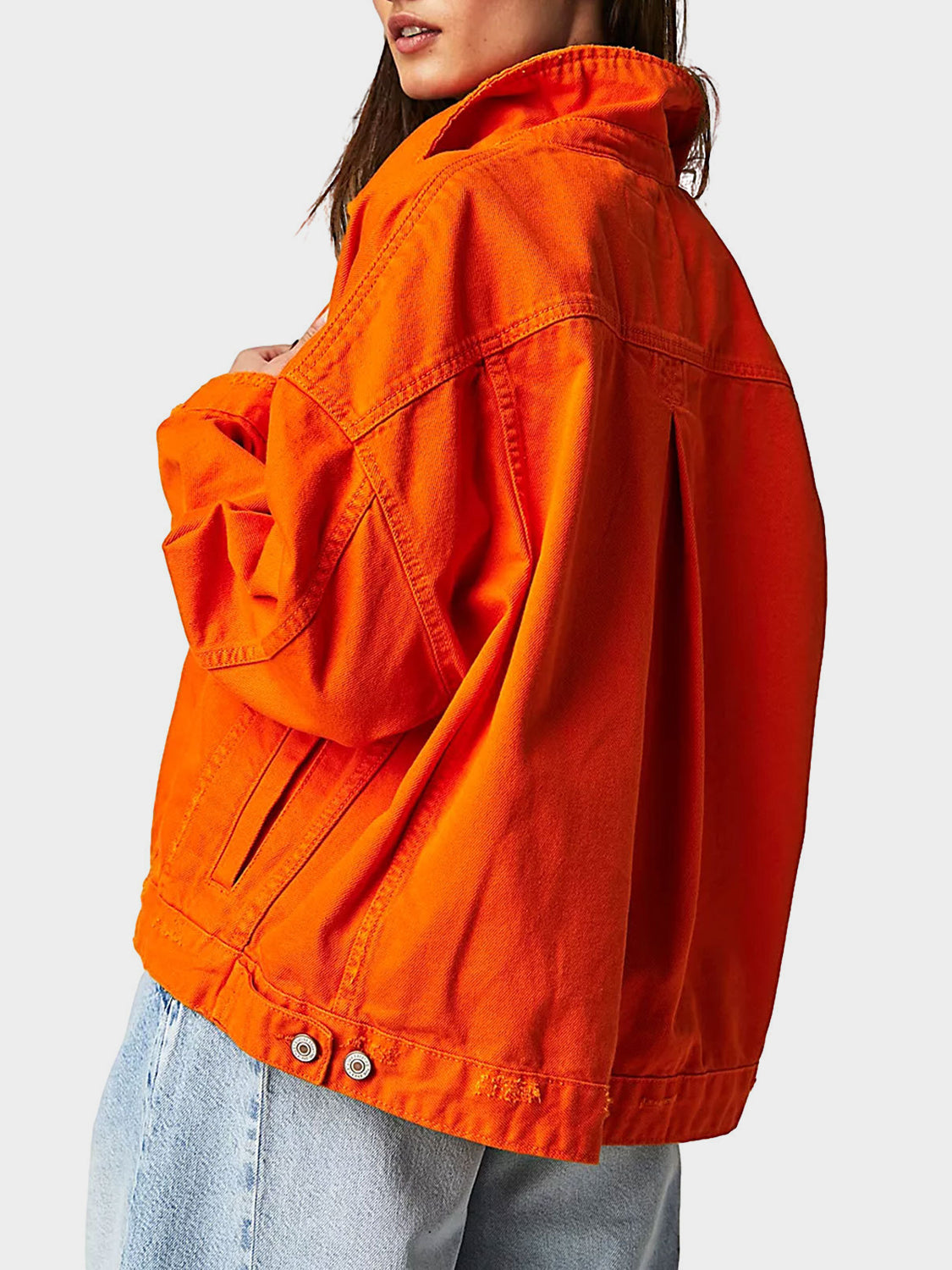 Sunset orange denim trucker jacket with button details and a relaxed fit.