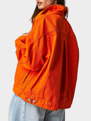Sunset orange denim trucker jacket with button details and a relaxed fit.