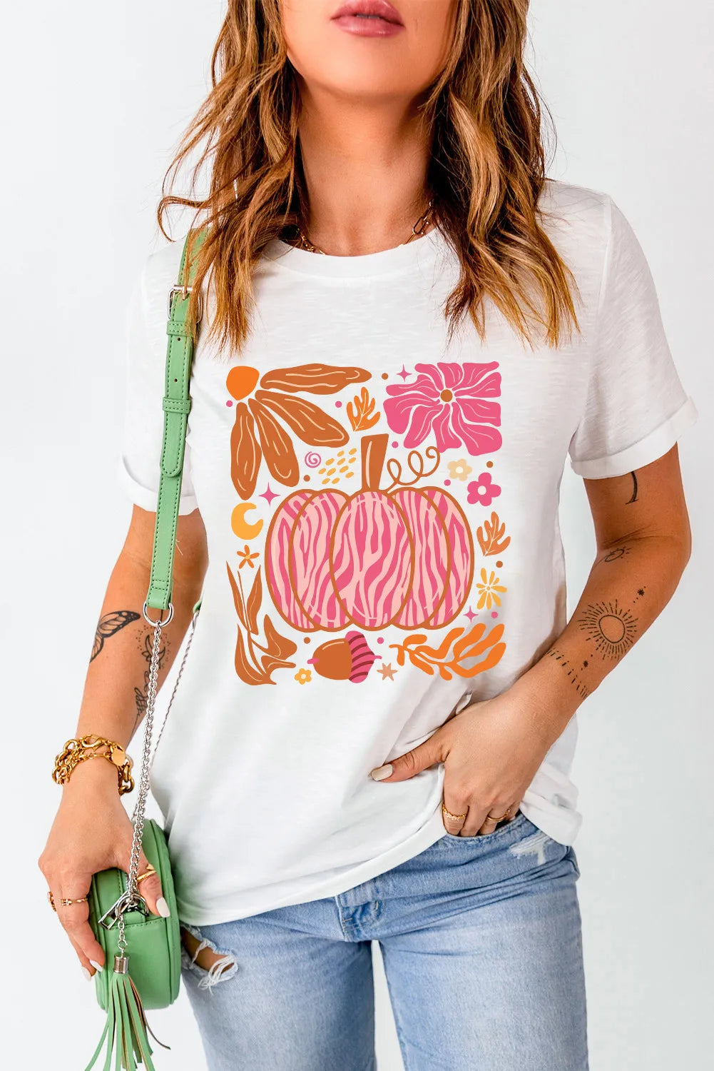 White crewneck tee with a pink and orange graphic pumpkin and floral design.