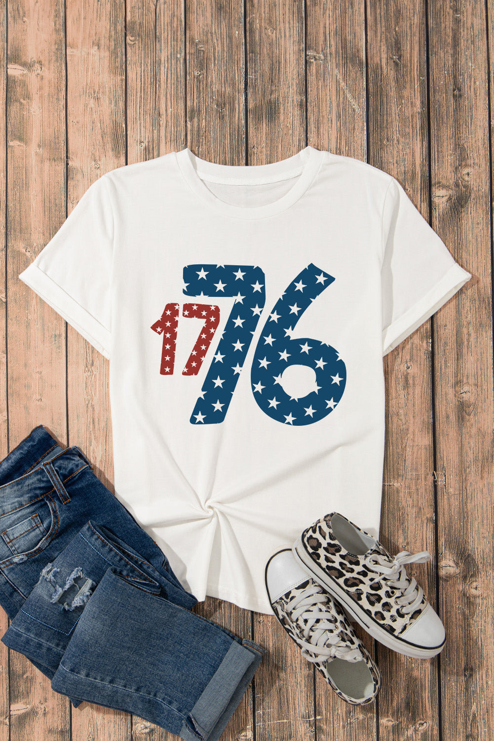 White graphic tee with patriotic 1776 star print, crew neck, short sleeves.