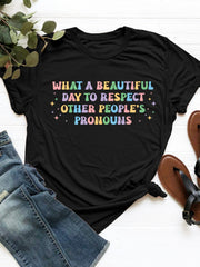 Black polyester t-shirt with "What a beautiful day to respect other people's pronouns" graphic in pastel colors.