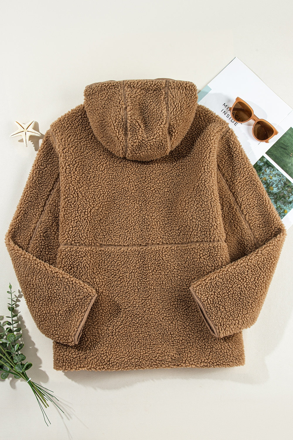 Brown sherpa hooded jacket with contrast trim and fleece lining.
