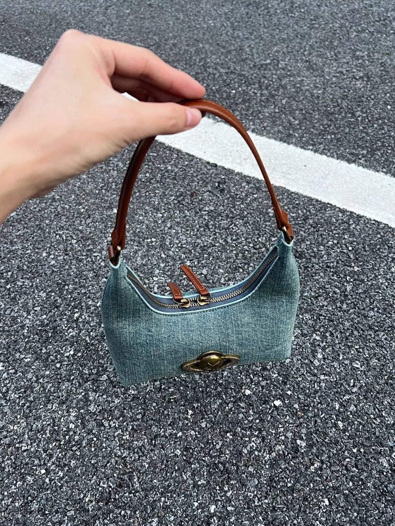 Mini denim shoulder bag with brown leather strap and gold hardware detail.