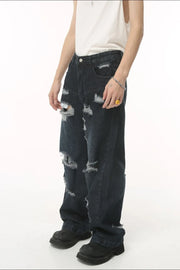 Distressed baggy dark wash denim jeans with statement rips and frayed hems.