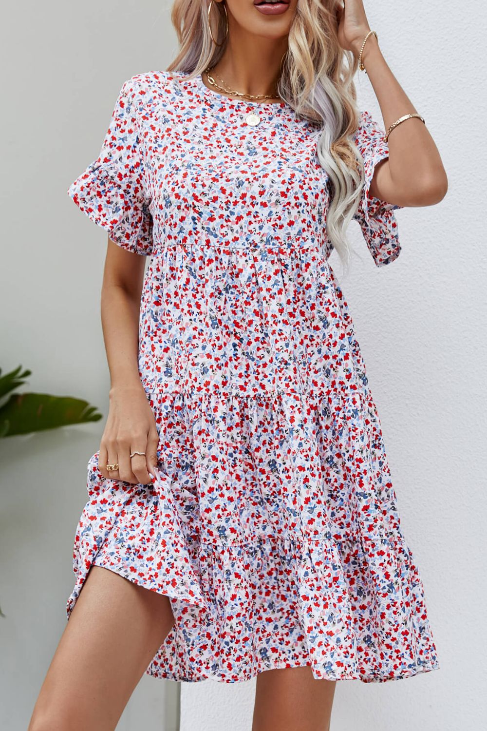 Miniature floral tiered babydoll dress with short flutter sleeves and round neckline.