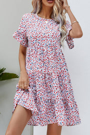 Miniature floral tiered babydoll dress with short flutter sleeves and round neckline.