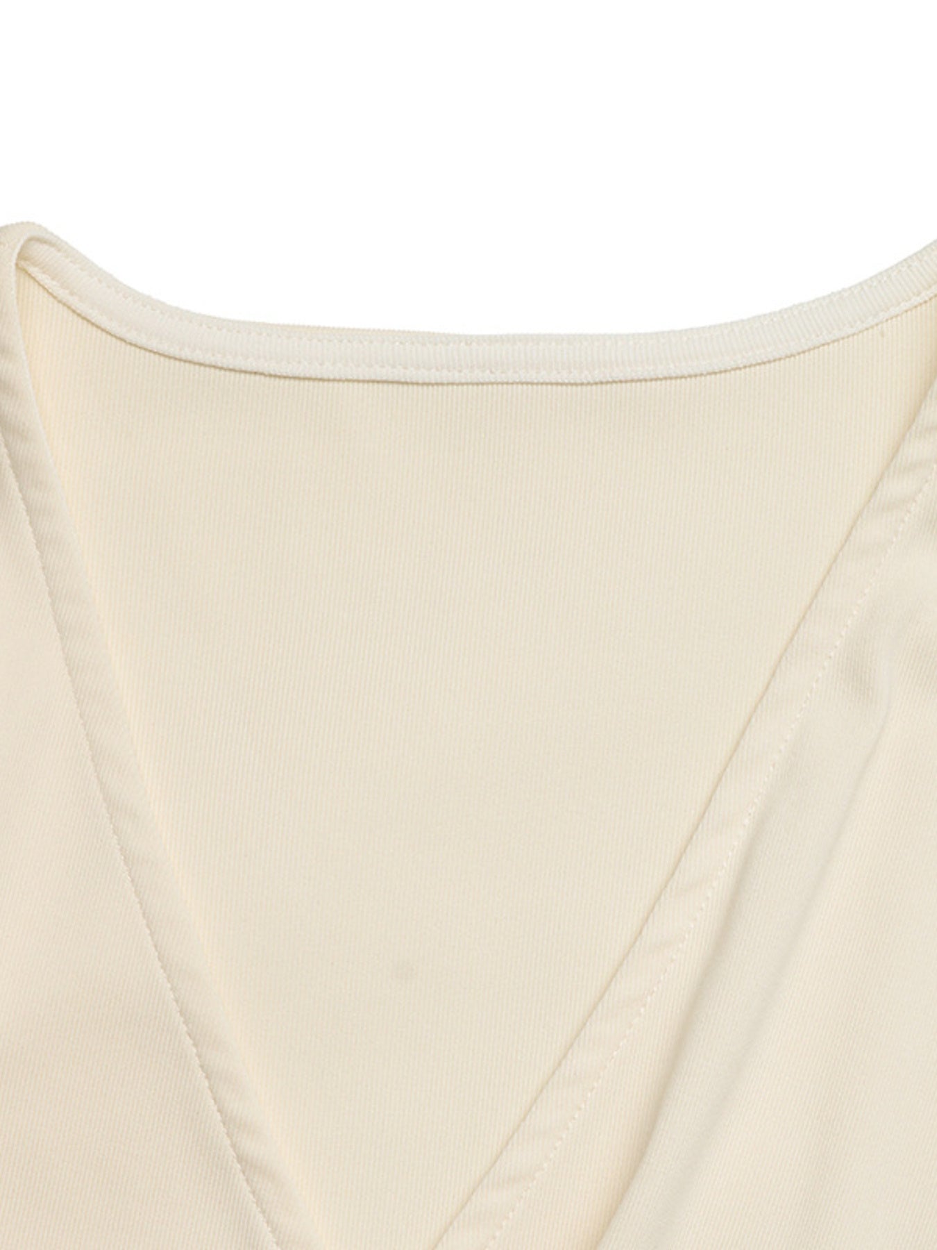 Cream surplice bodysuit with cap sleeves and a ribbed texture.