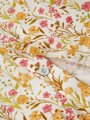Floral print button-down shirt dress with pink and orange flowers on white fabric.