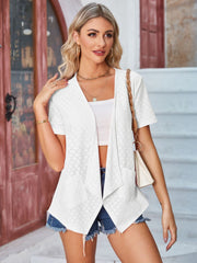 White perforated shawl collar jacket with short sleeves and open front, styled with denim shorts.