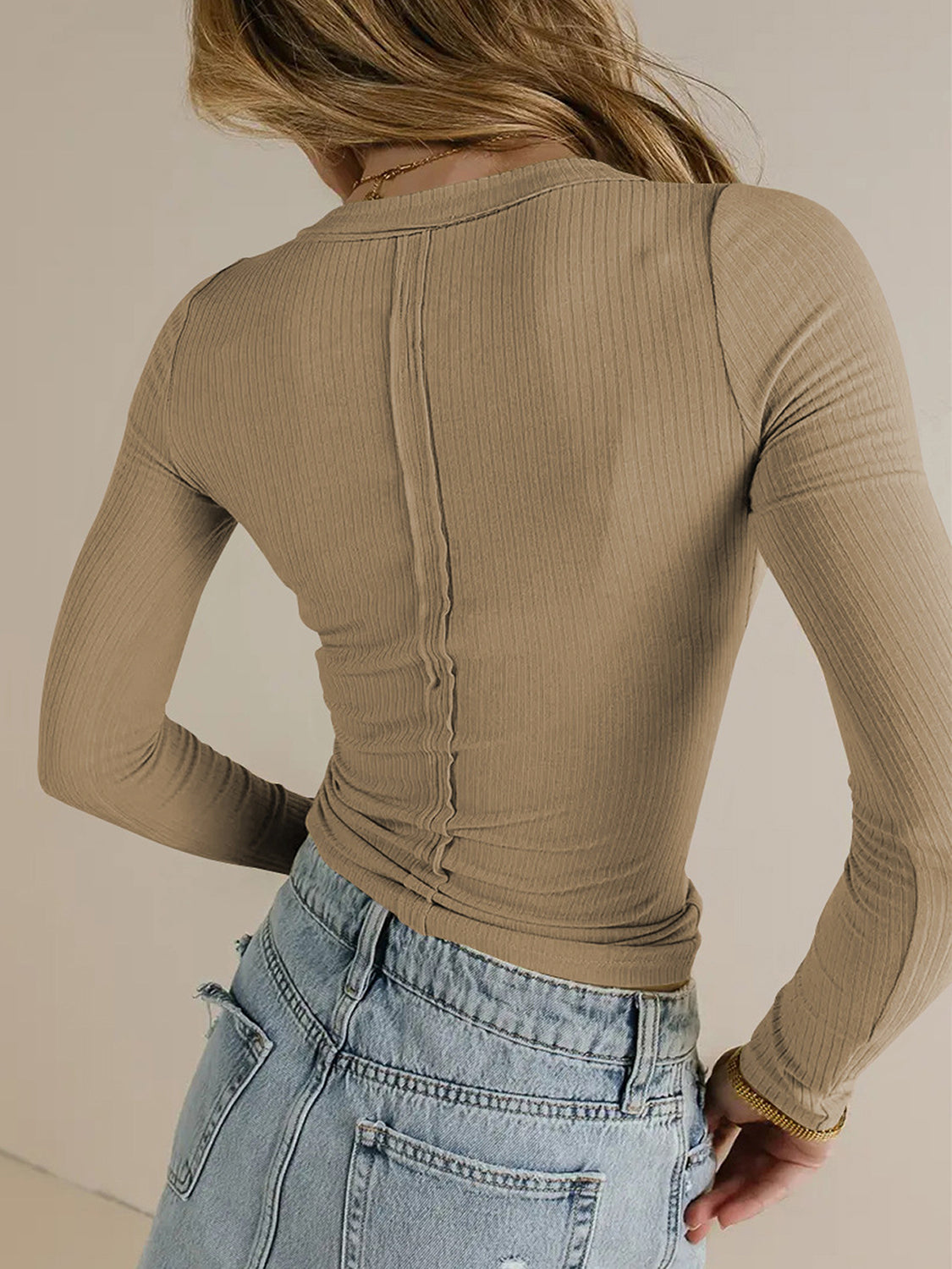Tan ribbed long sleeve top with a V-neck and seam detail down the back.