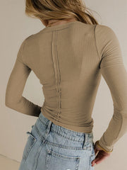 Tan ribbed long sleeve top with a V-neck and seam detail down the back.