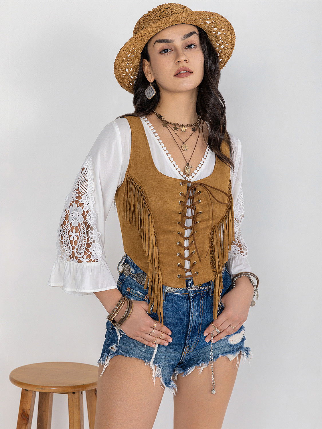 Tan suede fringe corset vest with lace-up front and boho styling.