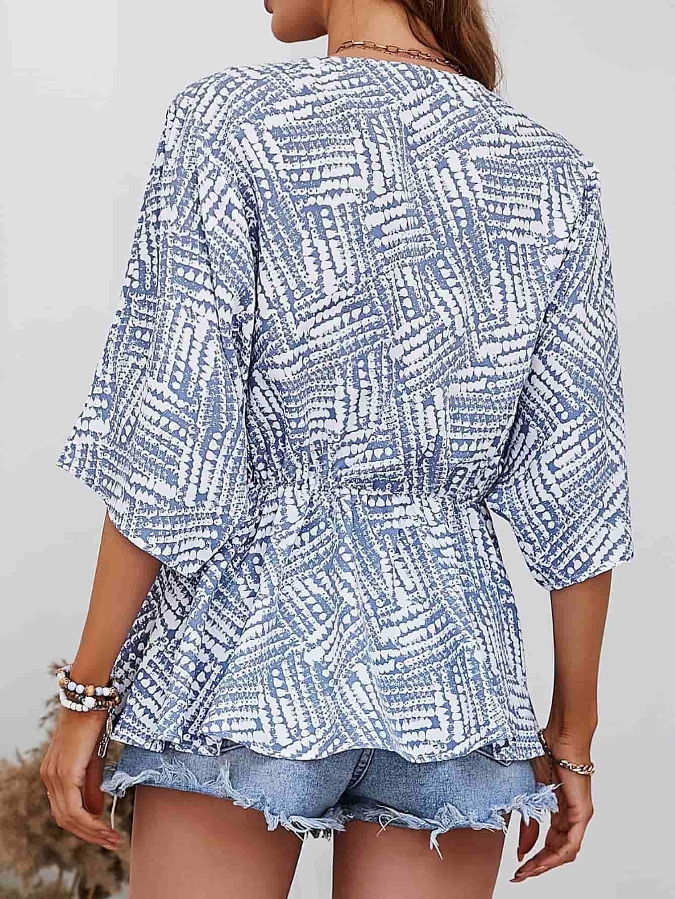 Light Blue abstract print cinched waist blouse with short sleeves and V-neck.