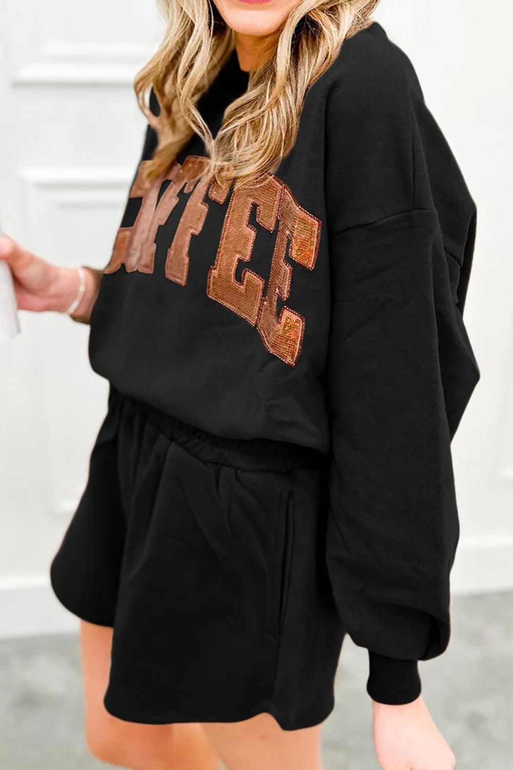 Black loungewear set with sequin coffee graphic on sweatshirt and elastic waist shorts.
