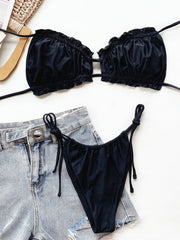 Black ruffle tie bikini set with string bikini bottoms and denim shorts.