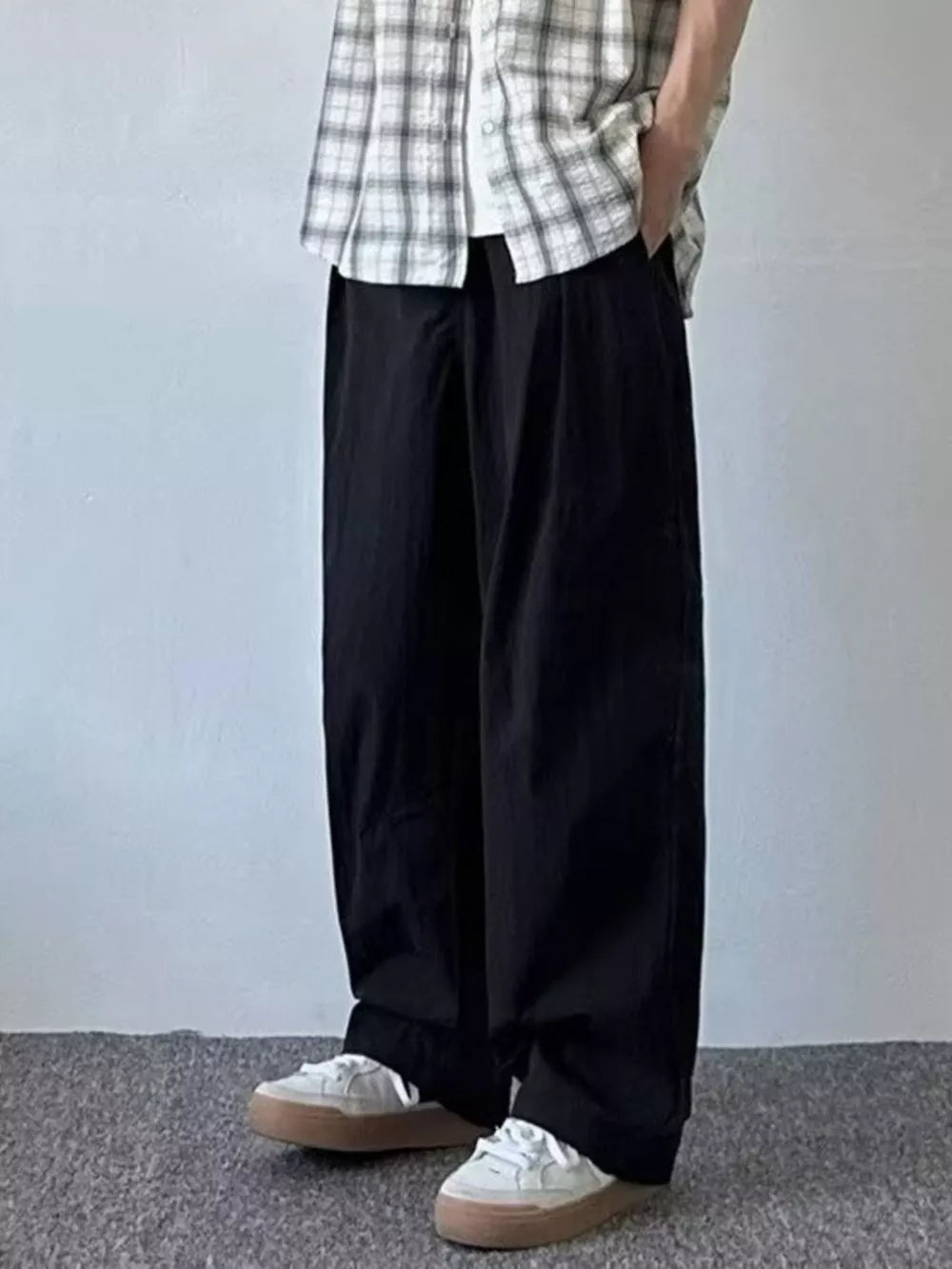 Relaxed fit black sweatpants for men with a loose, wide leg cut.