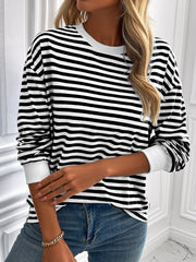 Black and white horizontal stripe crewneck sweatshirt with white cuffs.