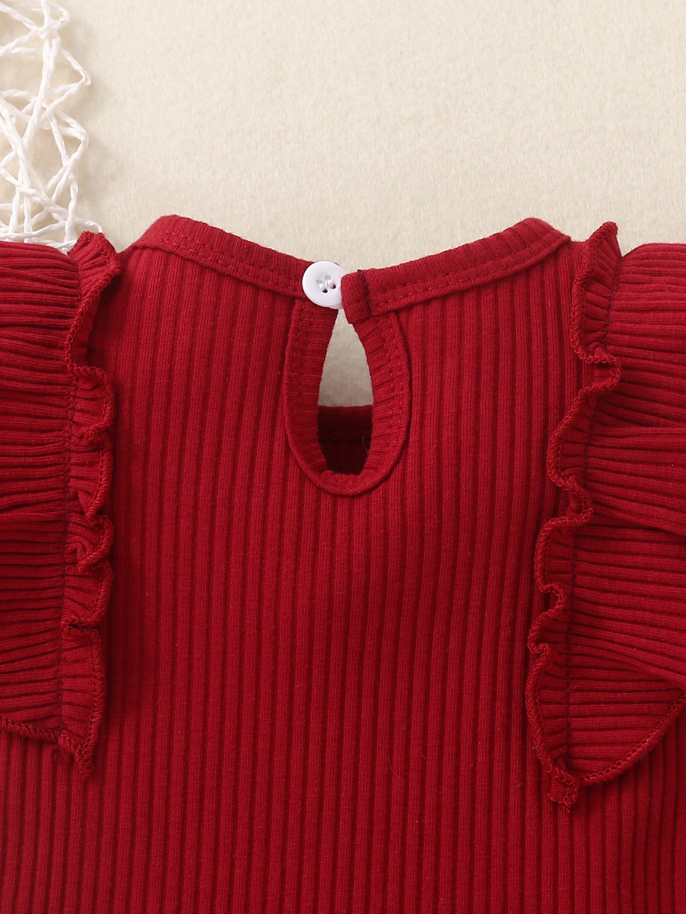 Red ribbed baby set with ruffle trim sleeves and button back closure.