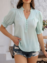Light green textured puff sleeve blouse with ruffled collar and button front.