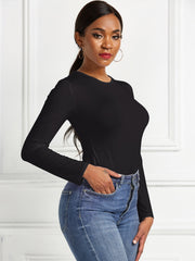 Black long sleeve ribbed bodysuit with crew neck, tucked into blue jeans.