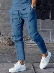 Casual drawstring sweatpants in denim blue with pockets and contrast stitching.