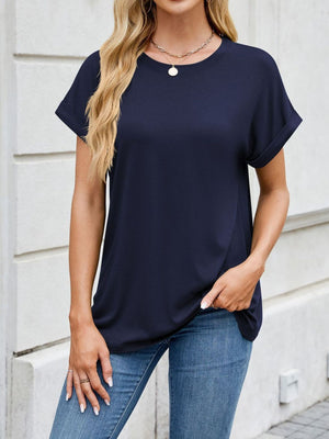 Basic navy crew neck t-shirt with cuffed short sleeves, styled with jeans.