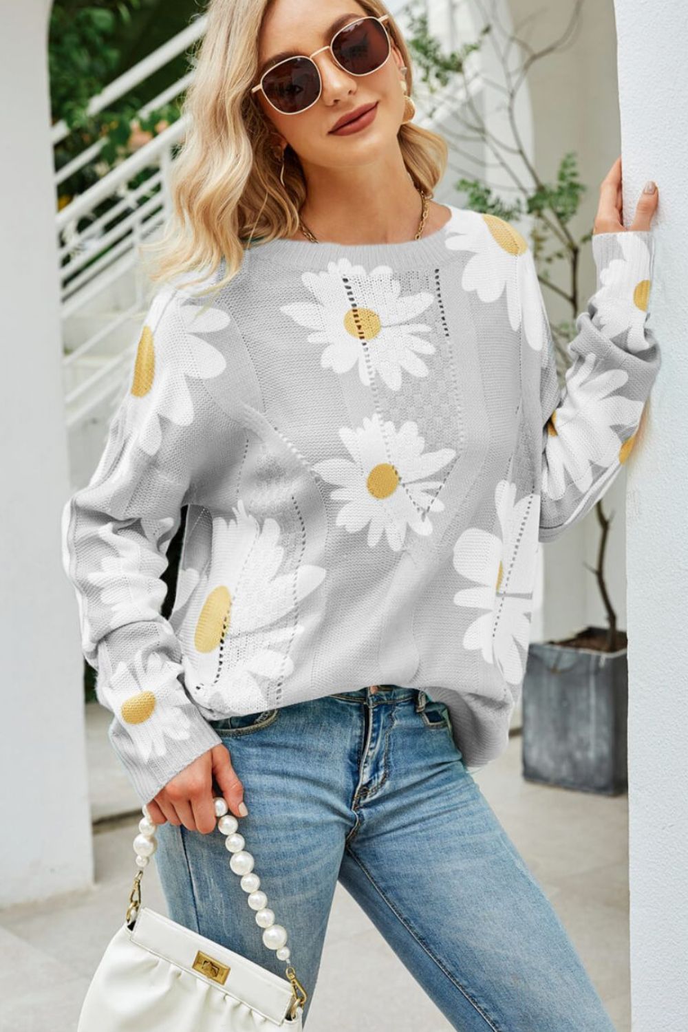 Light gray intarsia knit sweater with white daisy pattern and crew neck.