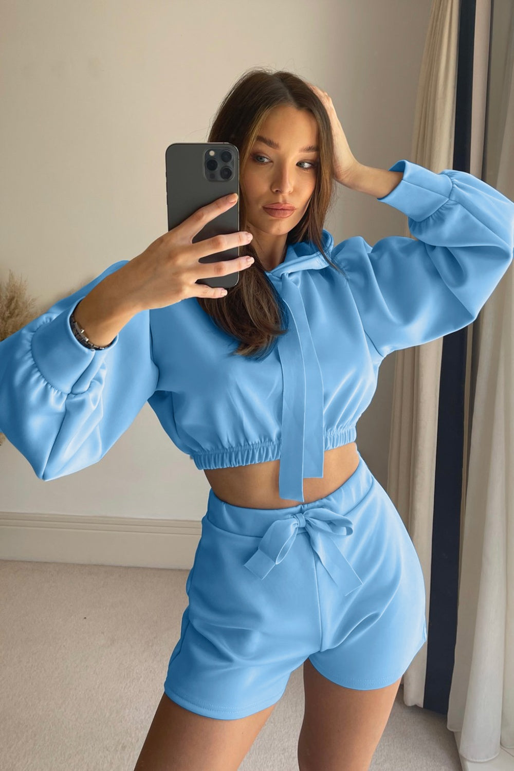 Light blue cropped hoodie and shorts set with tie details and balloon sleeves.