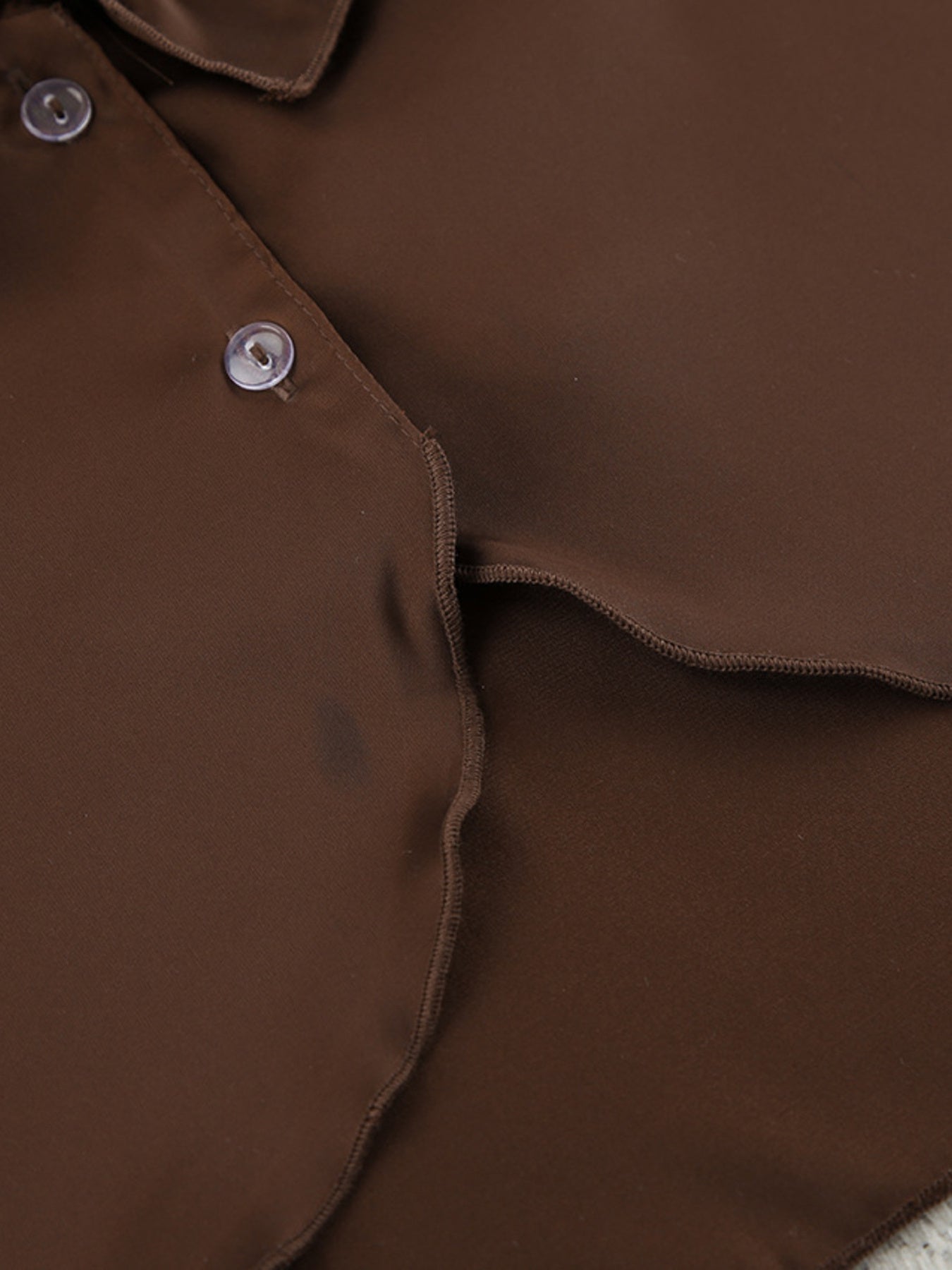 Chocolate ruffled V-neck pajama top detail with buttons and wavy hem.