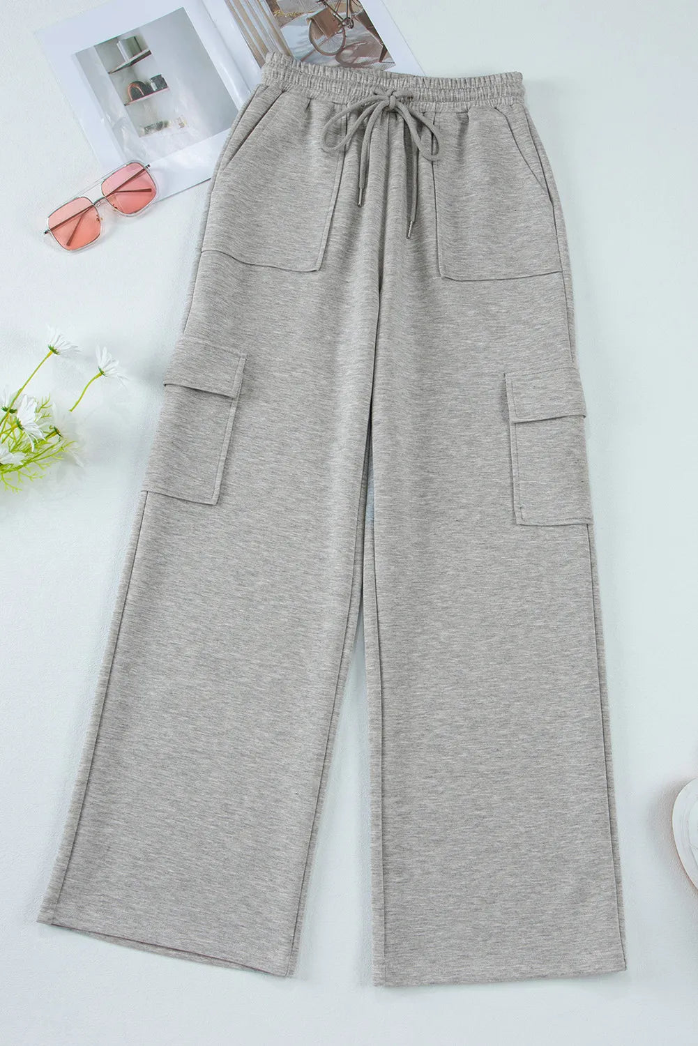 Gray wide-leg cargo lounge trousers with utility pockets and drawstring waist