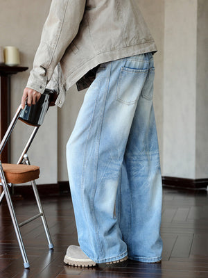 Men's light blue vintage wide leg jeans with distressed details and a relaxed fit.