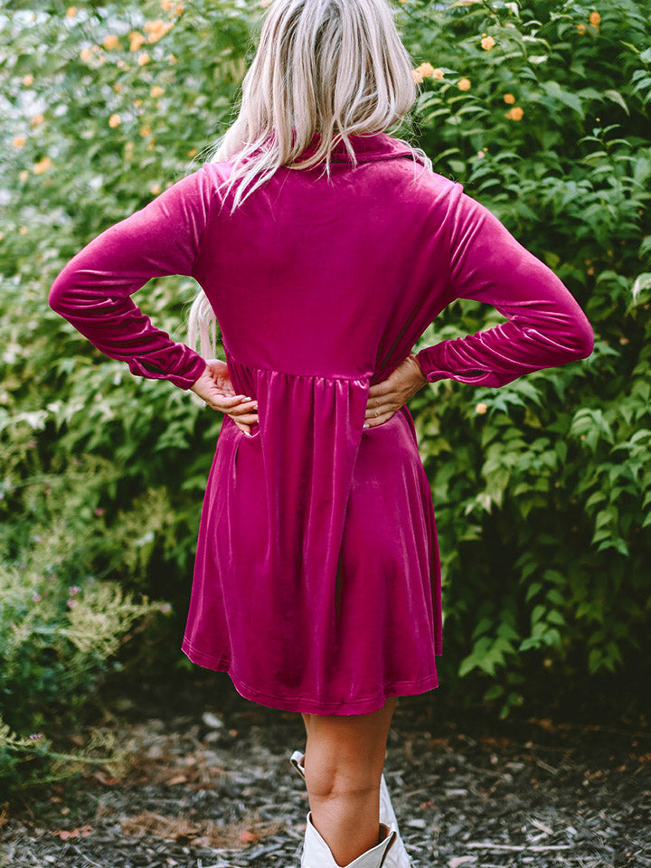 Deep Rose velvet babydoll button-down mini dress with a gathered waist and long sleeves.